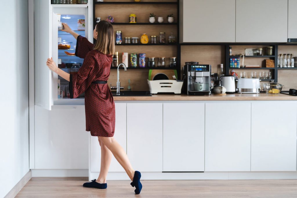 mulher a abrir frigorífico comprado com crédito eletrodomésticos