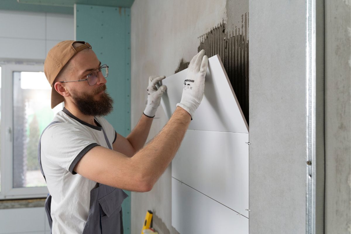 homem a montar placa em parede para efeitos de renovação